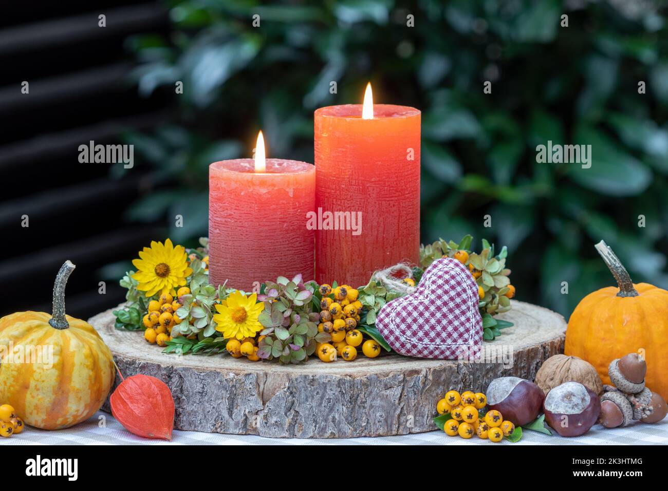 autumn arrangement with candles and wreath of flowers Stock Photo