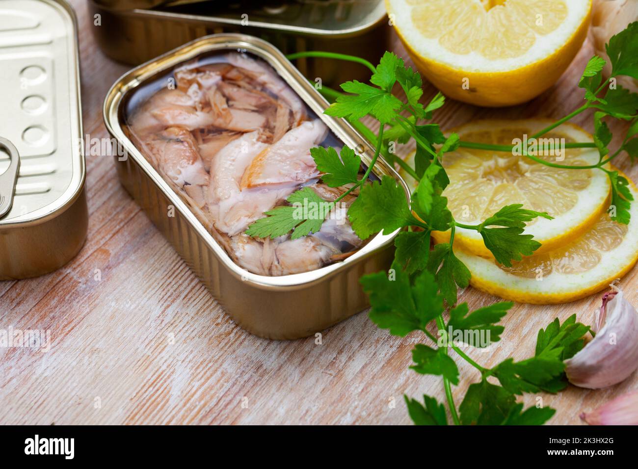 Canned fillet of tuna in open tin can on wooden desk Stock Photo