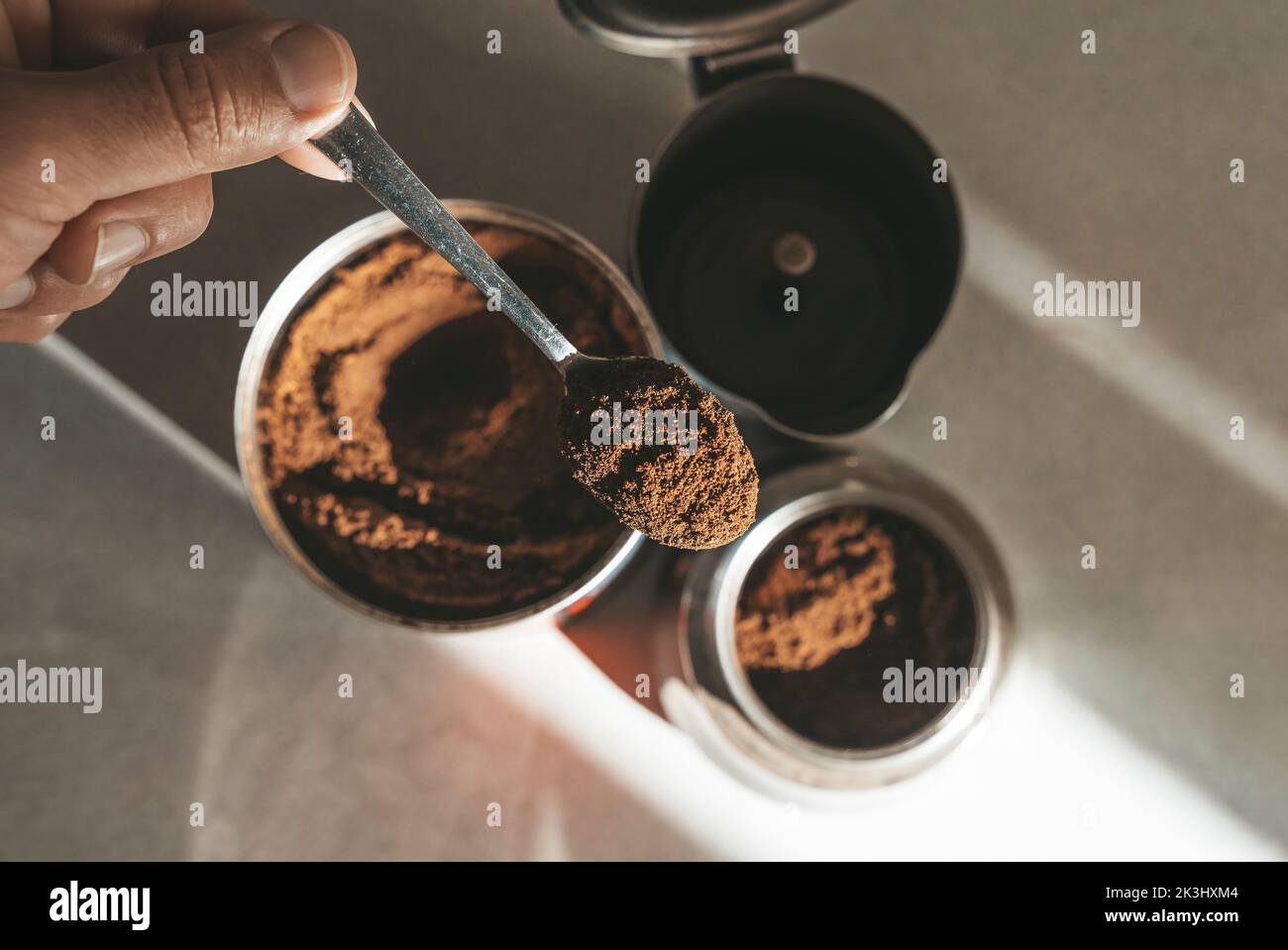 Metal coffee maker for brewing espresso on the stove. Teaspoon with ground coffee beans. High quality photo Stock Photo
