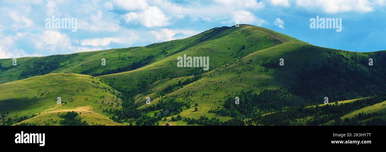 Green Zlatibor mountain hill landscape with beautiful clouds in background, panoramic image Stock Photo