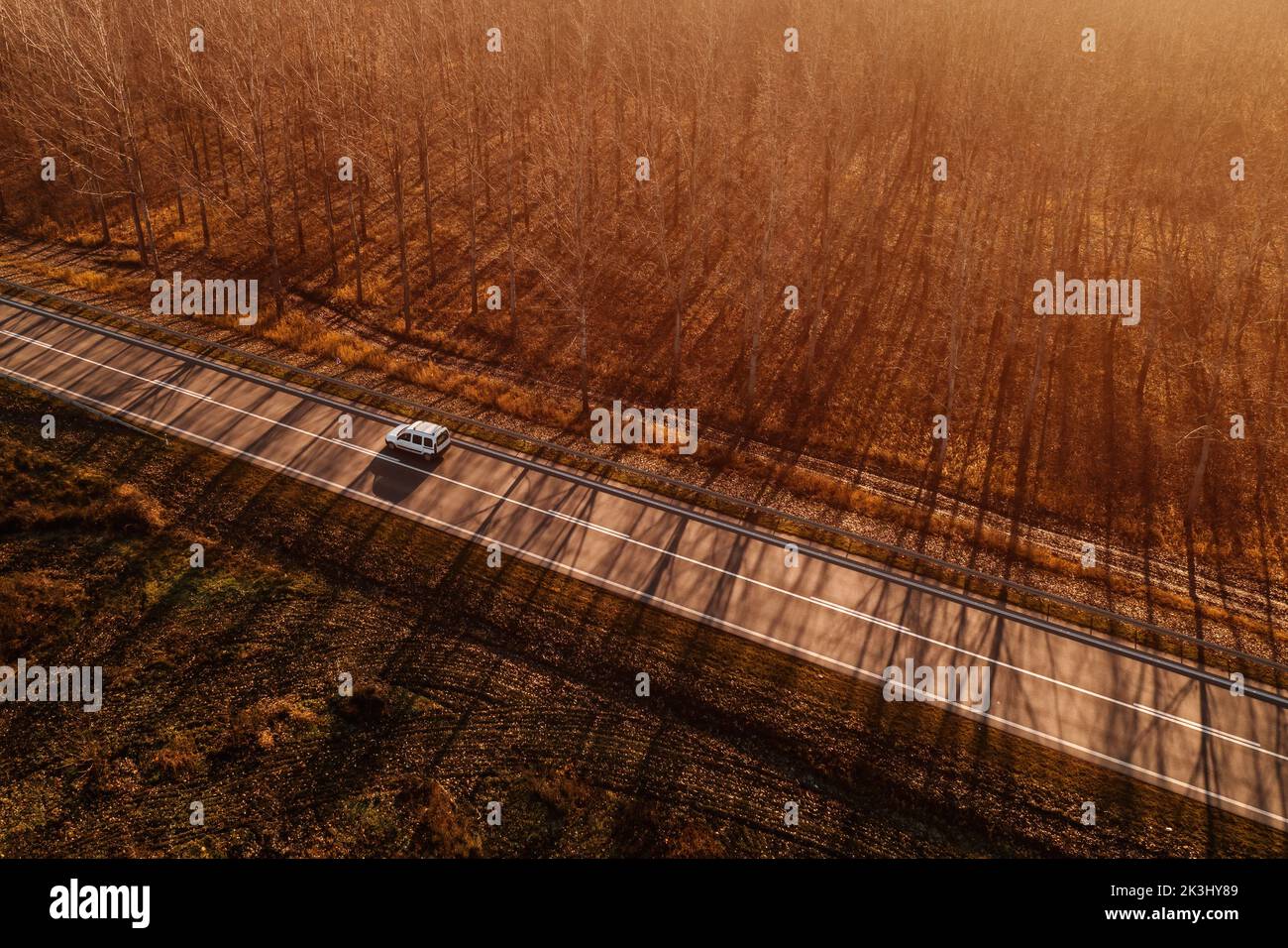 Aerial view of multi-purpose (mpv) or leisure activity (lav) vehicle mpv on road through autumn scenery landscape, drone phootgraphy Stock Photo