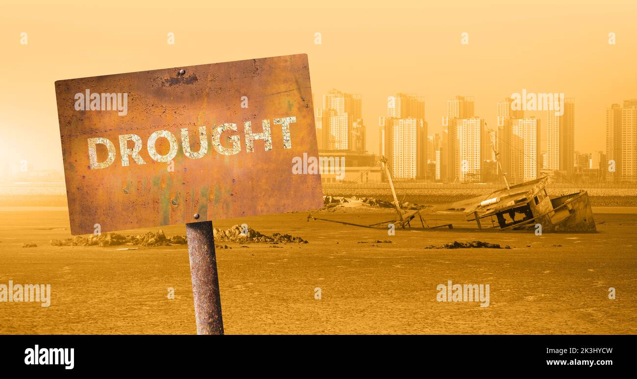 Rusty sign with the inscription DROUGHT on the background of the dried sea  Stock Photo