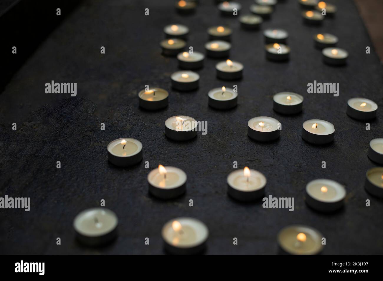 Lots of round whistles. Sign of remembrance. Burning wax candles. Details of funeral ceremony. Stock Photo