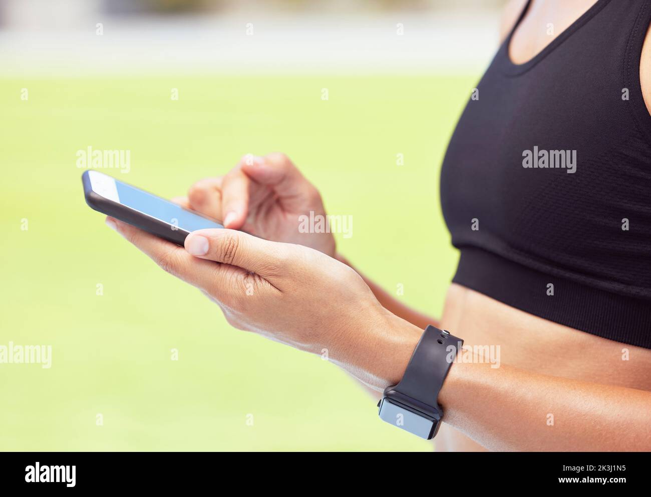 Fitness woman, phone app and hands of sports outside for exercise, training and workout for health and fitness. Closeup of active female athlete Stock Photo