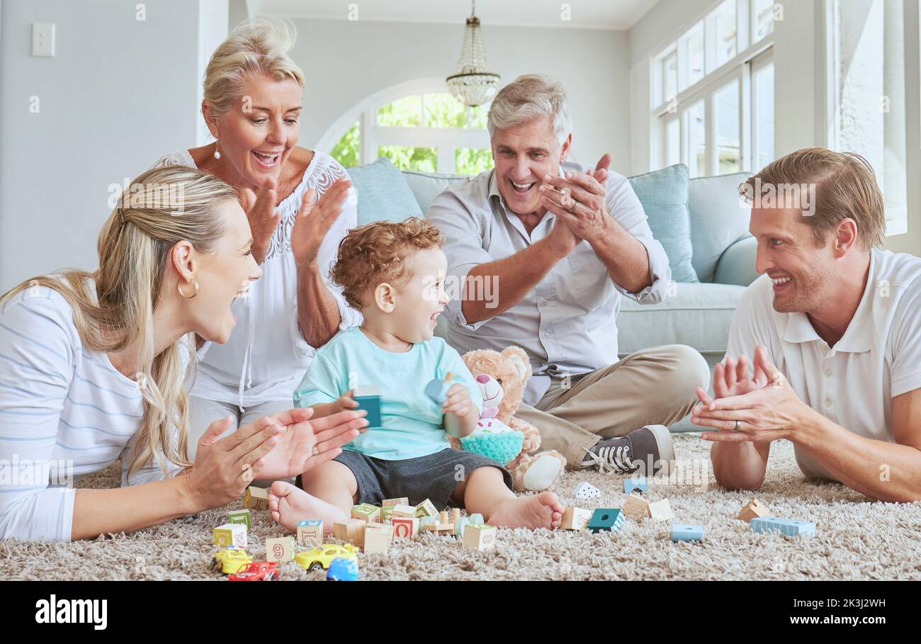 Family, clapping hands and baby playing with toys while sitting on the