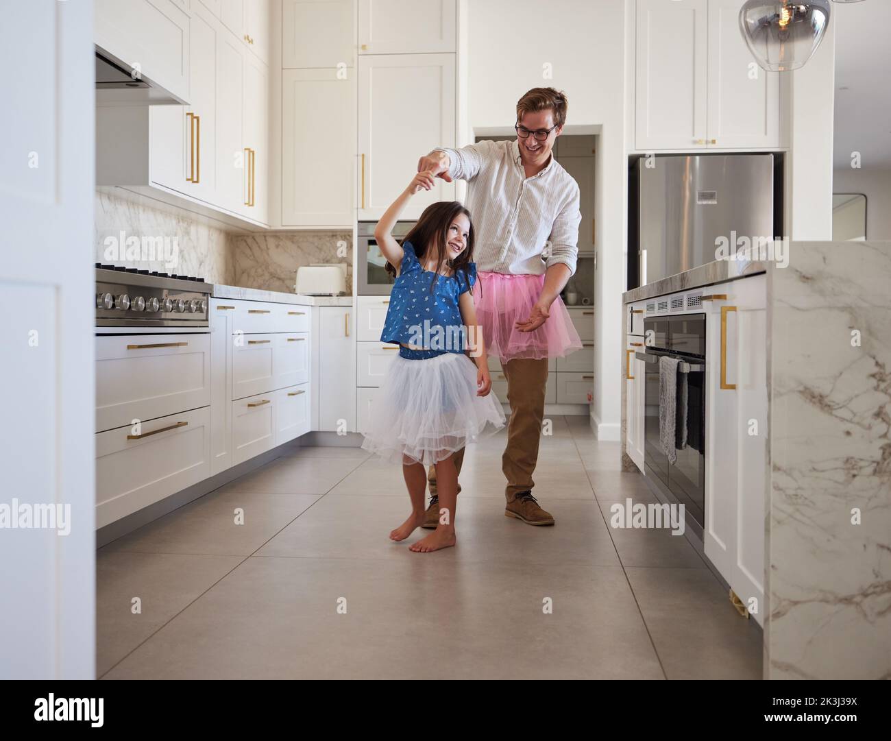 Happy family, dance and kitchen with father and daughter having fun, playing and enjoy freedom at home. Creative parent dressing up and dancing to Stock Photo
