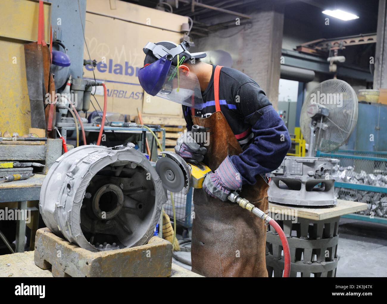 A worker cuts a cast at Mitchell Aerospace, Inc., a manufacturer of light alloy sand castings for the aerospace industry, in Montreal, Quebec, Canada September 9, 2022.  REUTERS/Christinne Muschi Stock Photo