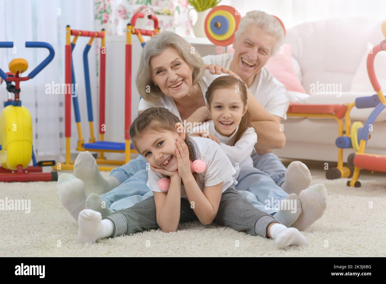 Grandfather and grandmother together with their granddaughters are training  Stock Photo