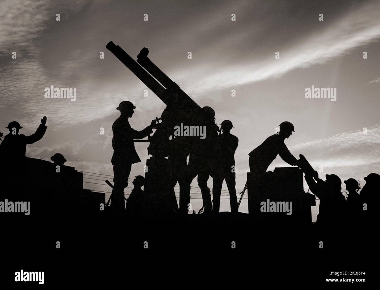 Soldiers silhouetted against the sky prepare to fire an anti-aircraft gun. On the right of the photograph a soldier is being handed a large shell for the gun. The Battle of Broodseinde was part of the 1917 third Battle of Ypres – engineered by Sir Douglas Haig to capture the Passchendaele ridge. Stock Photo