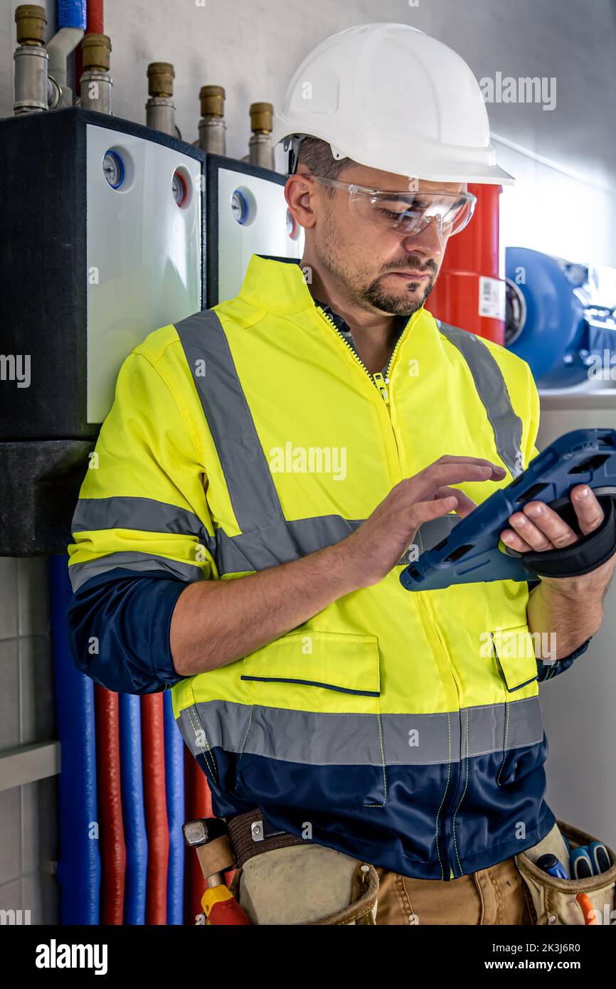 Electrical technician looking focused while working in a switchboard with fuses. Stock Photo