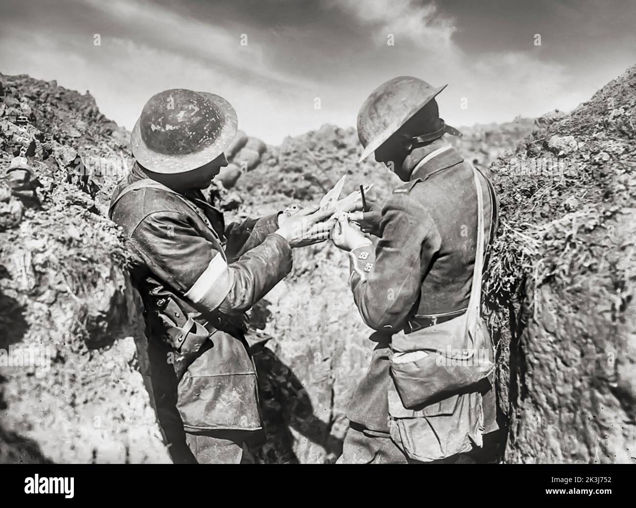 A message is attached to a carrier pigeon by British troops on the Western Front in 1917. One of France’s homing pigeons, named Cher Ami, was awarded the French “Croix de Guerre with Palm” for heroic service delivering 12 important messages during the Battle of Verdun. Stock Photo