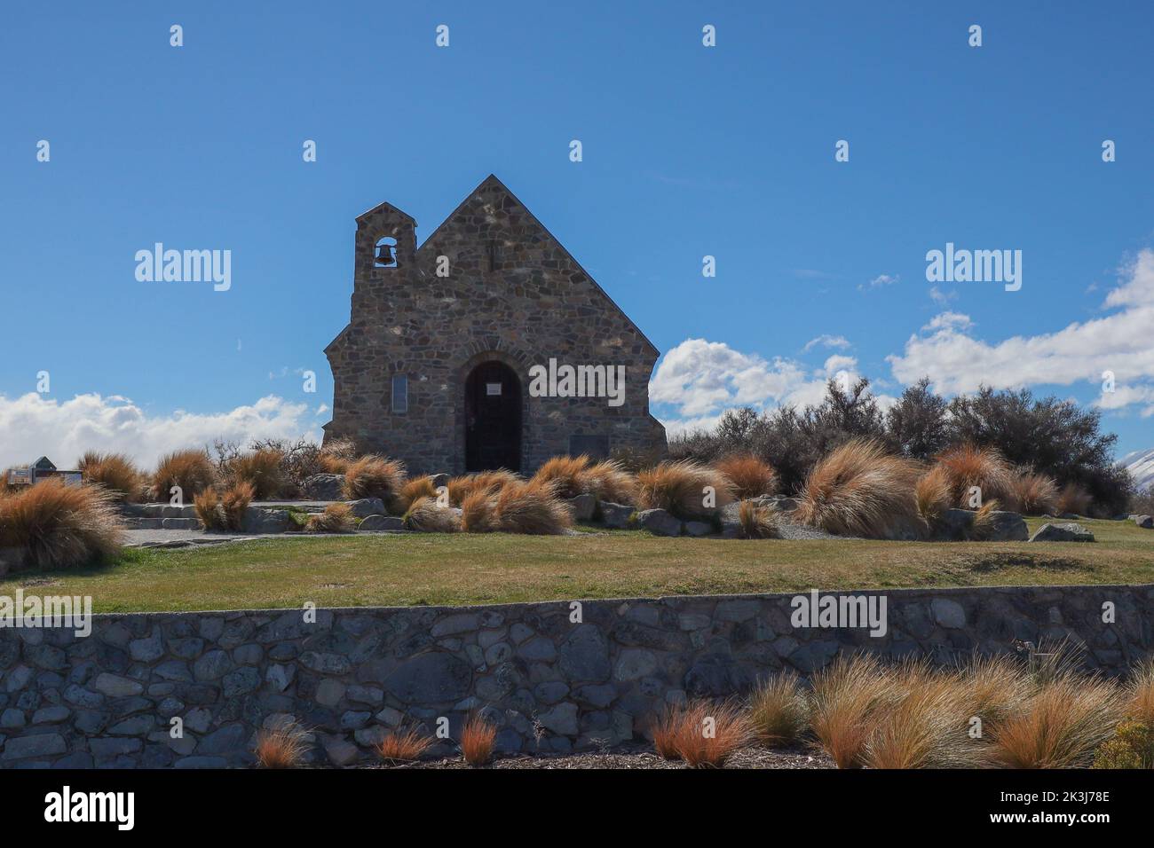 A Good Shepherd church view with precinct view, yellow tussock grass around and blue sky background Stock Photo
