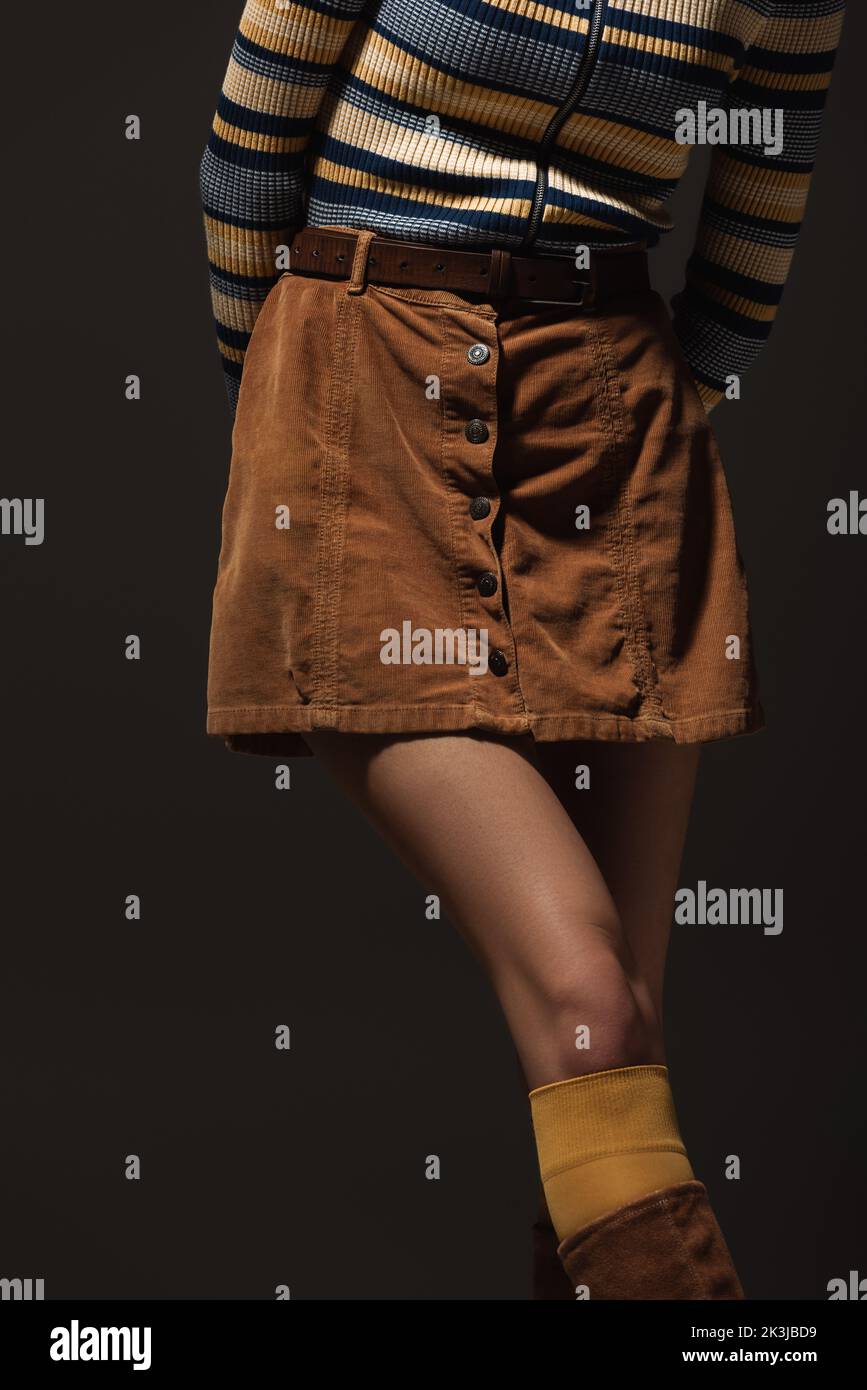 cropped view of young woman in autumnal skirt standing isolated on black,stock image Stock Photo