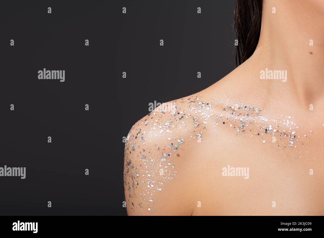 cropped view of young woman with sparkling glitter on clavicle and bare shoulder isolated on grey,stock image Stock Photo