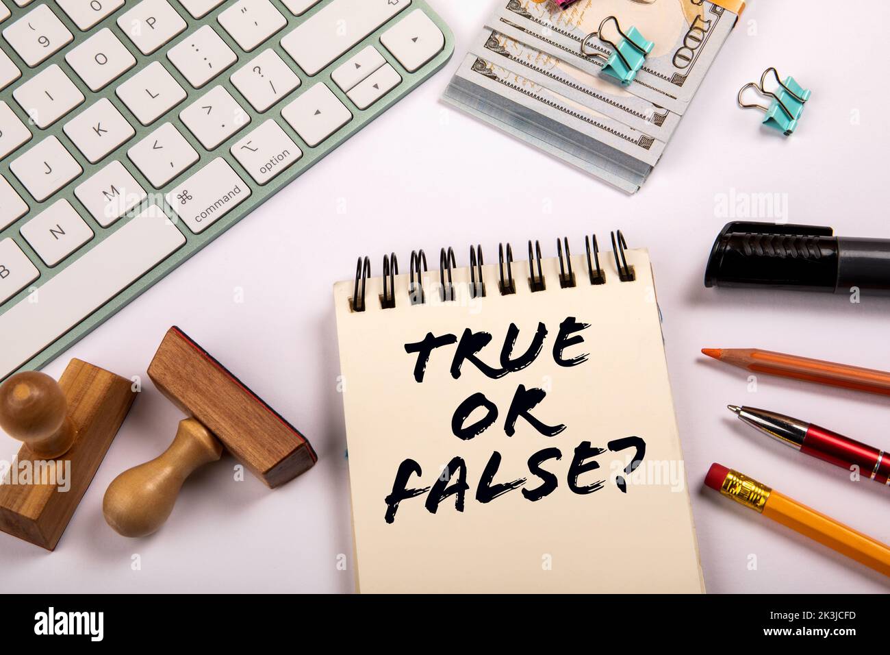 True or False. Money and stationery on a white office table. Stock Photo