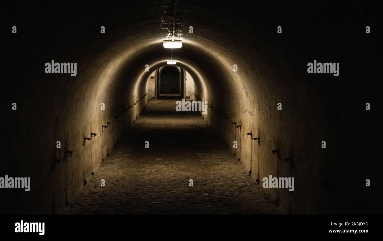 First person view walking through the military tunnel in the dungeon. Defensive structure, casemates. Bomb shelter during the war. Copy space for text Stock Photo