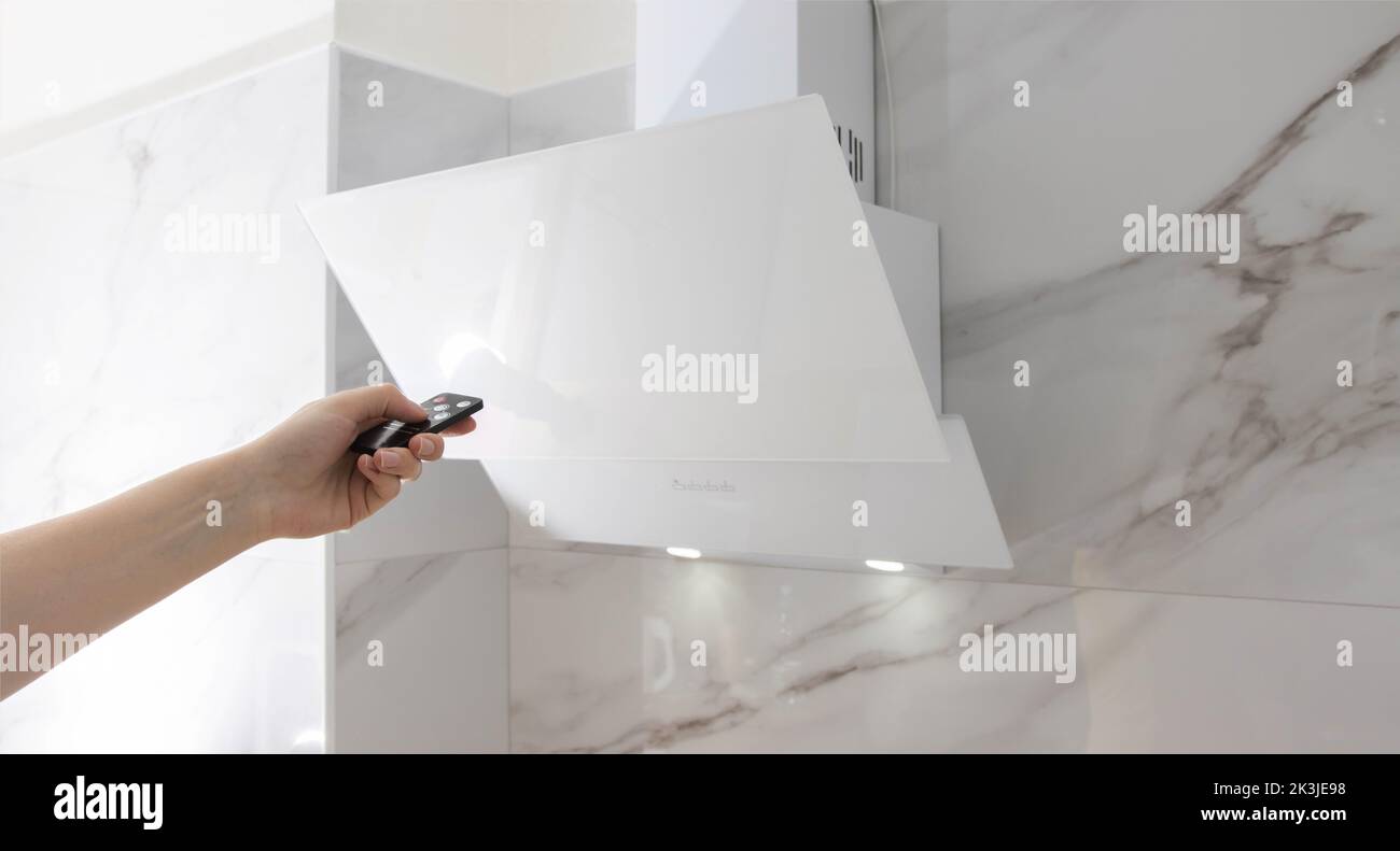 Inclined modern kitchen hood on a white wall with porcelain stoneware