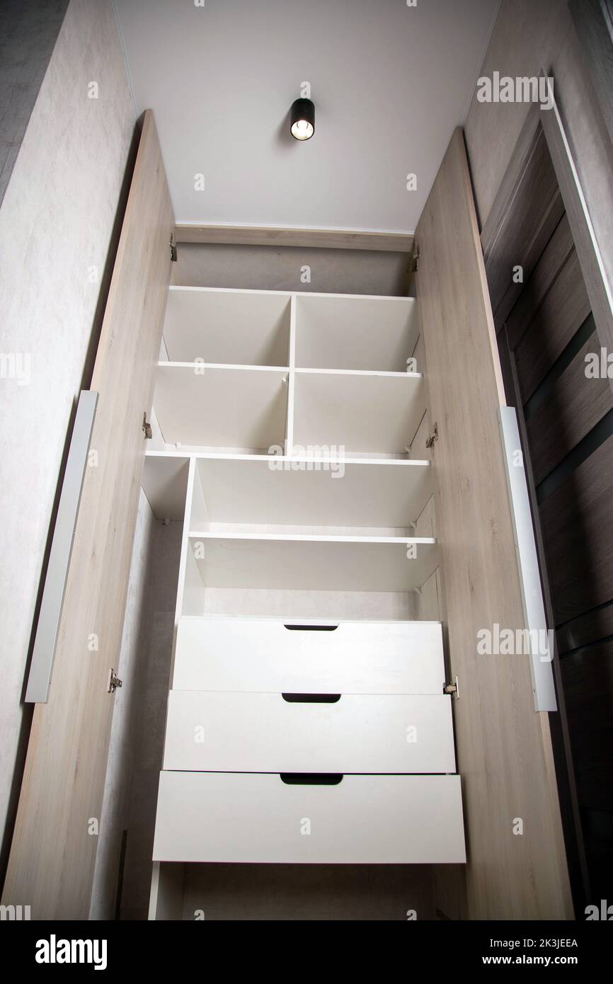 Modern closet in the hallway with hinged doors and pullout shelves