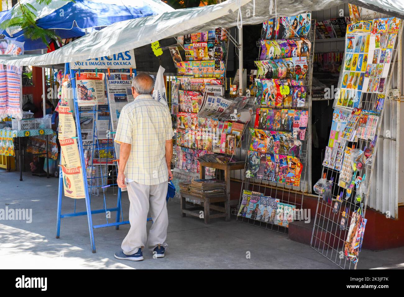 Man reading newspapers at a newstand in Mercado Sánchez Pascuas, Oaxaca city, Mexico Stock Photo