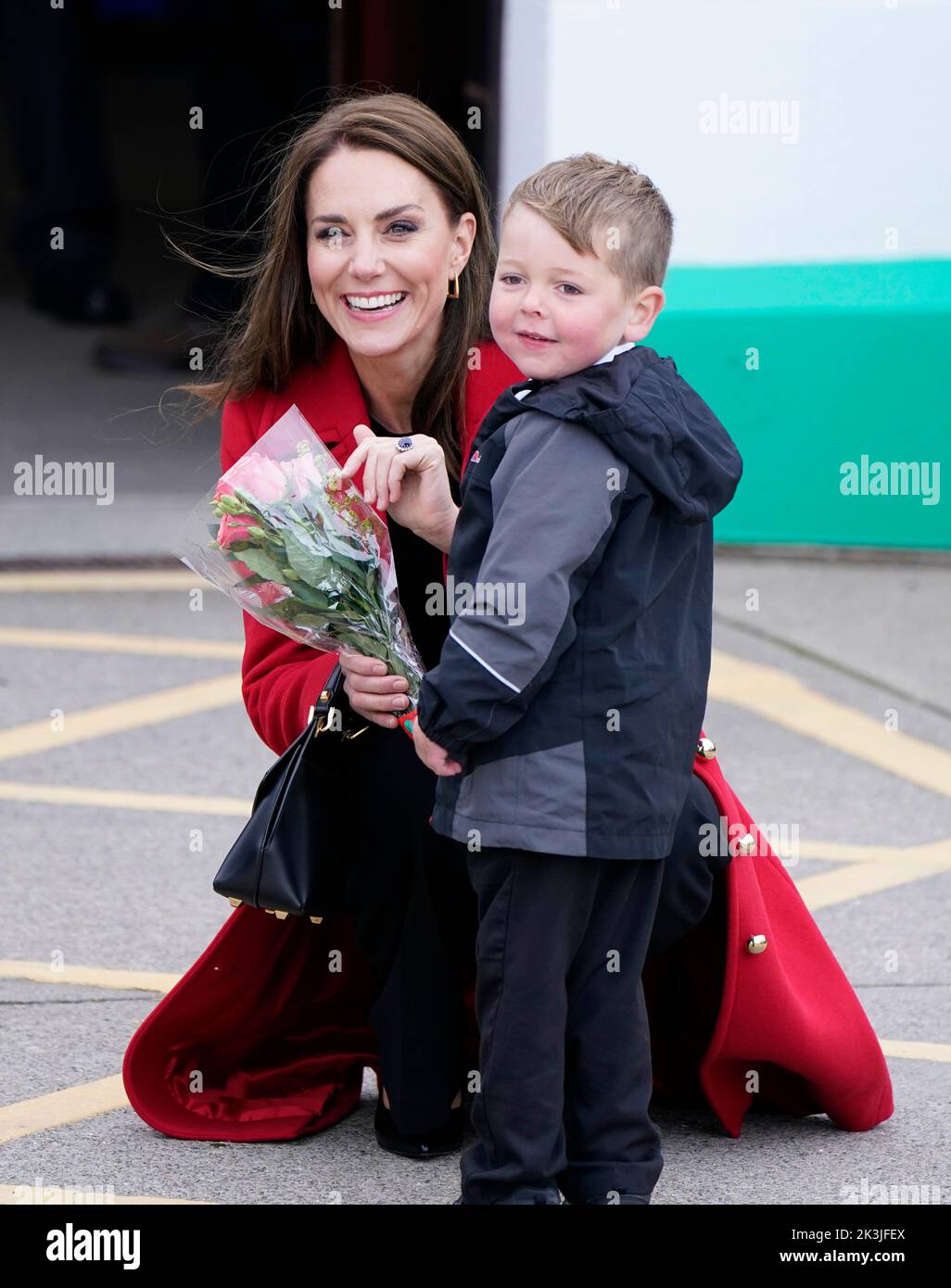 RETRANSMITTING ADDING NAME The Princess of Wales receives a posy of flowers from four-year-old Theo Crompton as she arrives for a visit to the RNLI Holyhead Lifeboat Station, in Holyhead, Wales, where with the Prince of Wales they are meeting crew, volunteers and some of those who have been supported by their local unit. Holyhead is one of the three oldest lifeboat stations on the Welsh coast and has a remarkable history of bravery, having received 70 awards for gallantry. Picture date: Tuesday September 27, 2022. Stock Photo