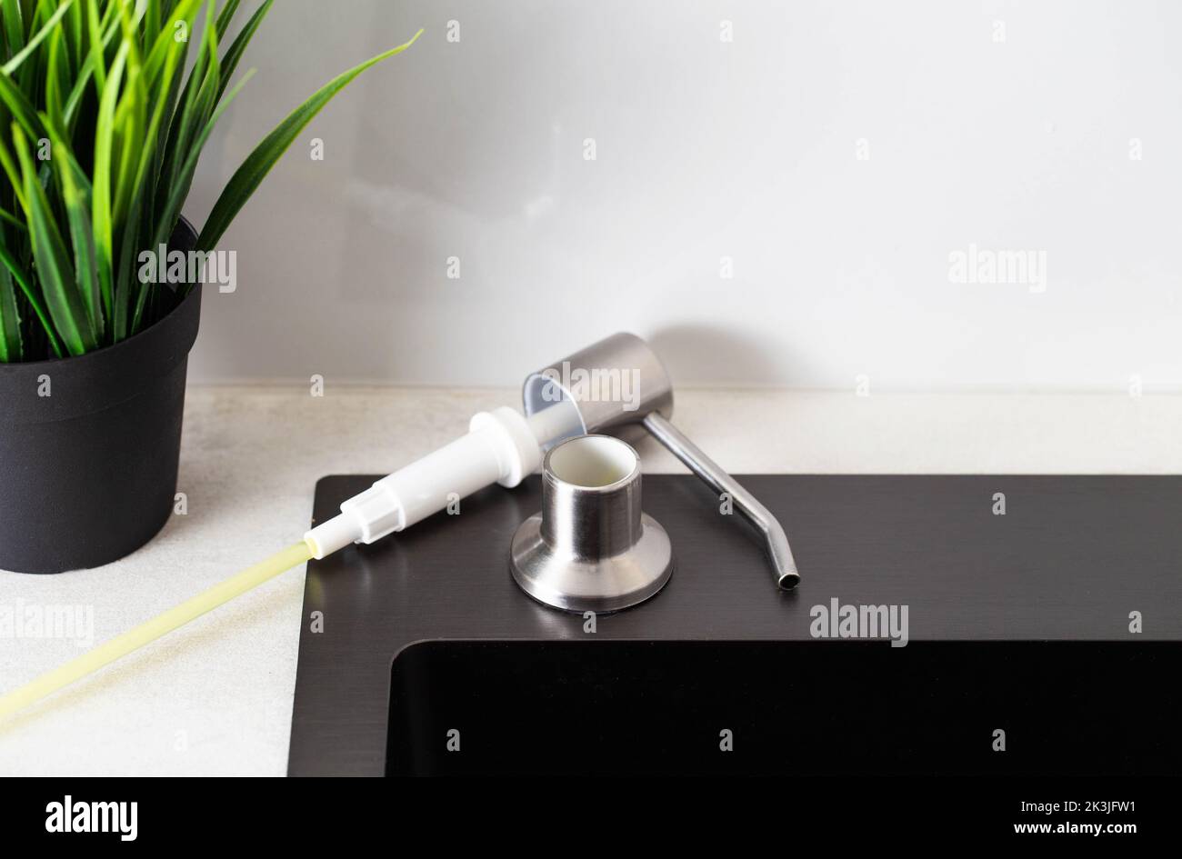 Dismantled detergent dispenser built into the sink. Adding soap to the