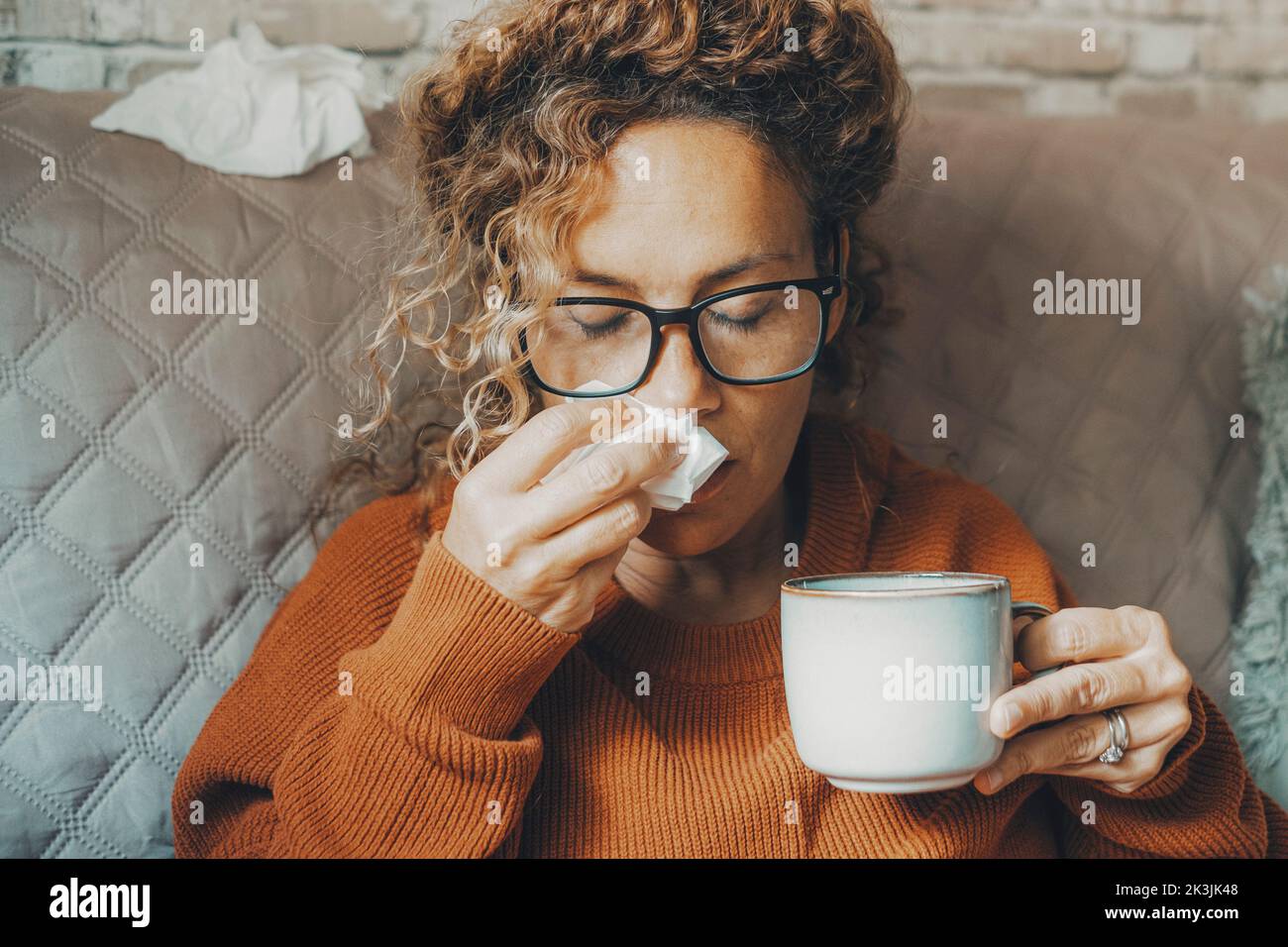 Sick woman at home blowing nose and take care of influenza virus ...