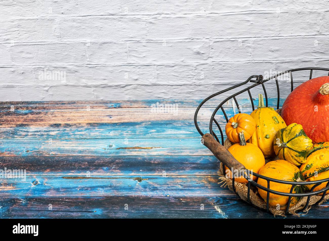 Still life with various ornamental gourds in an old wire basket Stock Photo