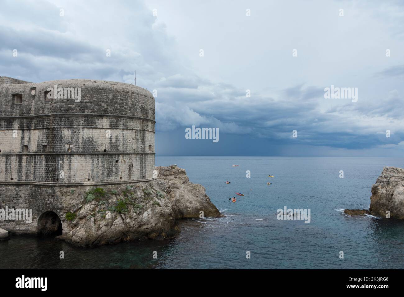 Bokar Fortress seen from West Harbour in Old Town of Dubrovnik with kayakers and rain clouds in the background. Dalmatia, Croatia, Europe. Stock Photo