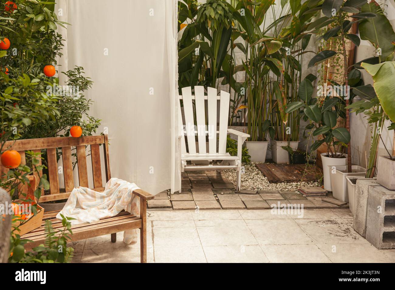 Vintage garden with wooden bench and white chair Stock Photo