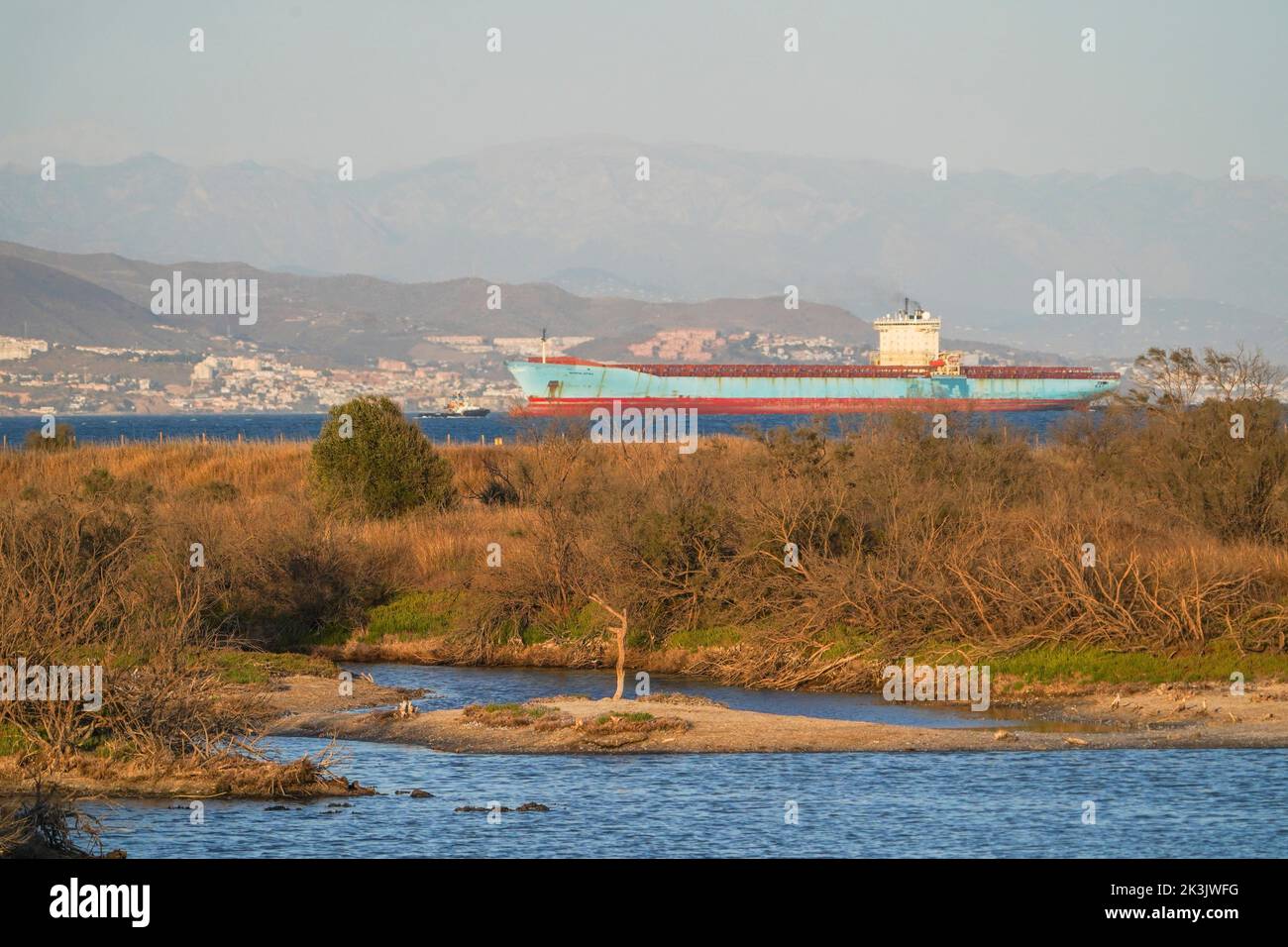 Container ship MAERSK KOTKA, near Malaga, with Guadalhorce natural park in front, Andalucia, Spain. Stock Photo