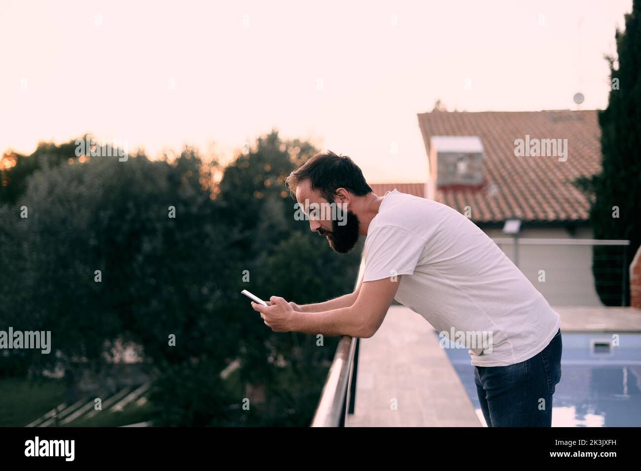 Young man using a chat app in his forest house Stock Photo