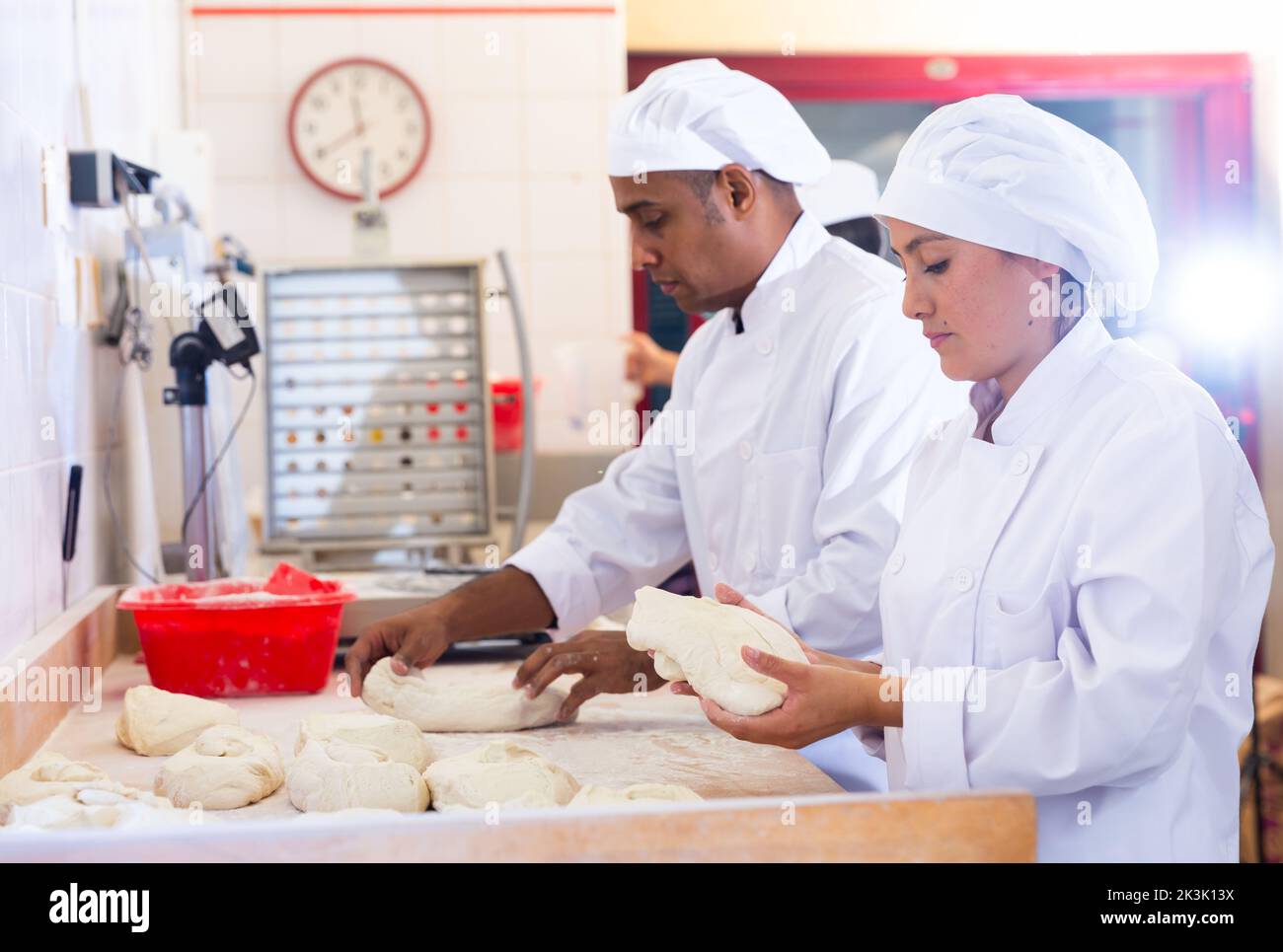 Male and female baker working together in bakery Stock Photo