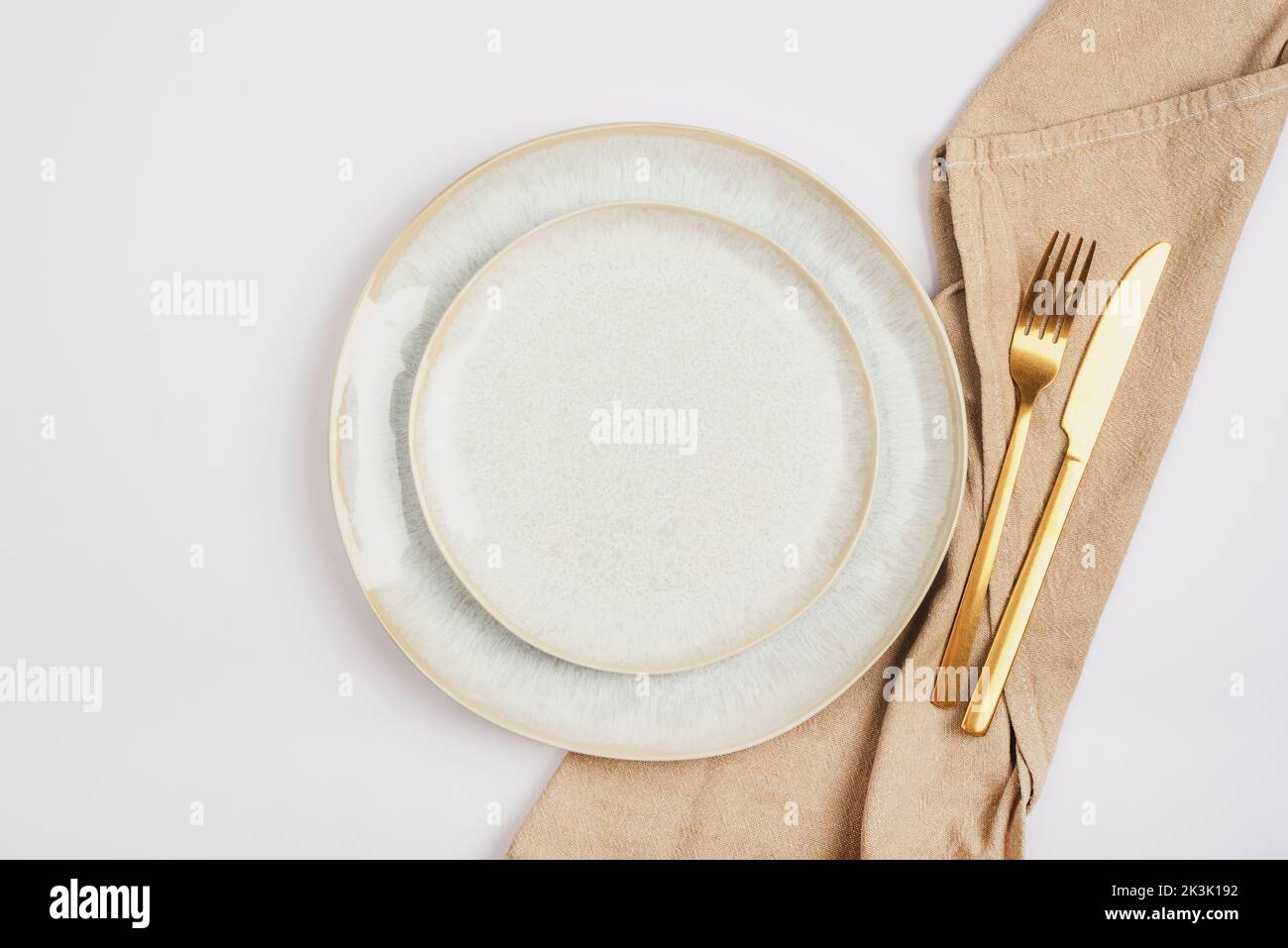Empty plate and fork and knife with napkin on white background. Table setting. Top view, flat lay. Stock Photo