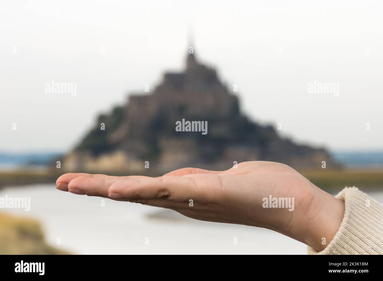 Scenic view of hand holding Mont Saint-Michel in Normandy, France as a treasure Stock Photo