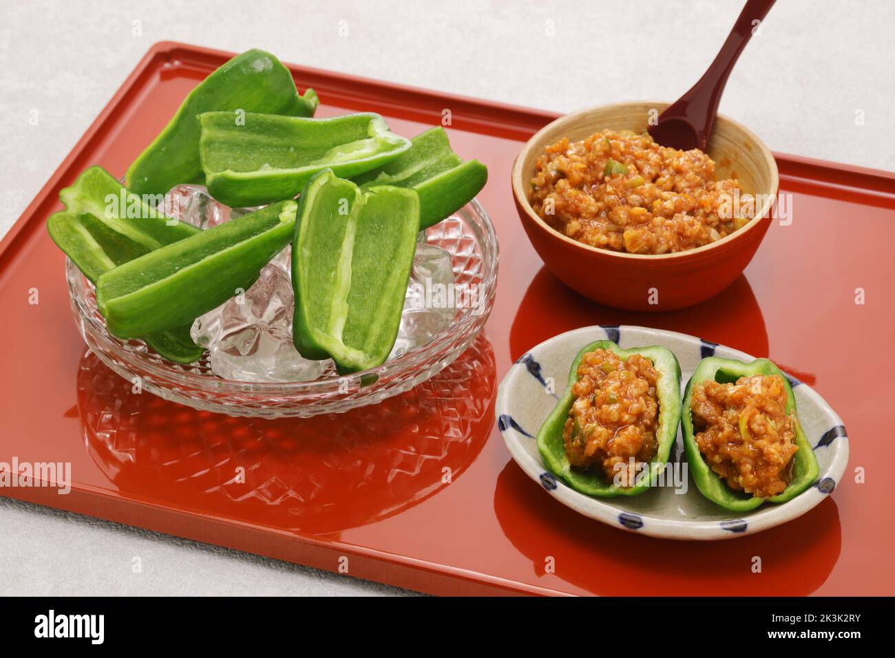 fresh green peppers(chilled in ice water) and Niku Miso (ground pork miso dip), a Japanese tavern appetizer Stock Photo