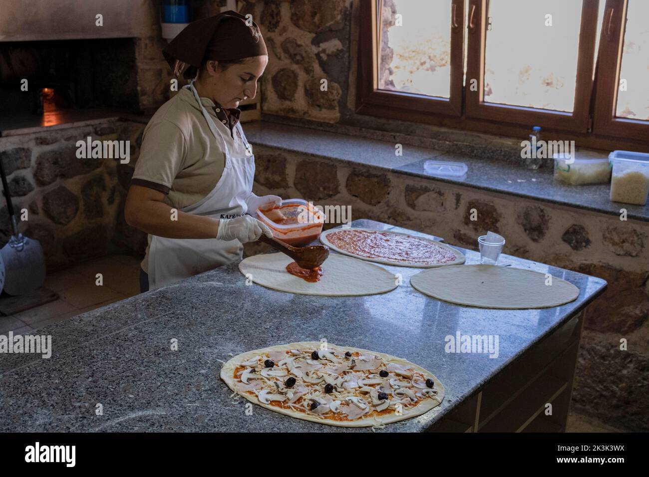 A worker seen preparing pizzas at Kafro's Pizza, Mardin. There is a
