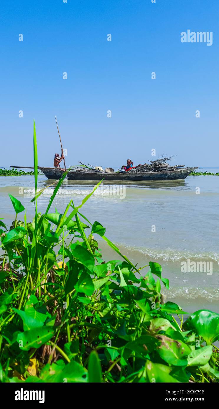 Bangladeshi traditional fishing boat on Meghna river. Fisherman in a small boat on the river. Stock Photo