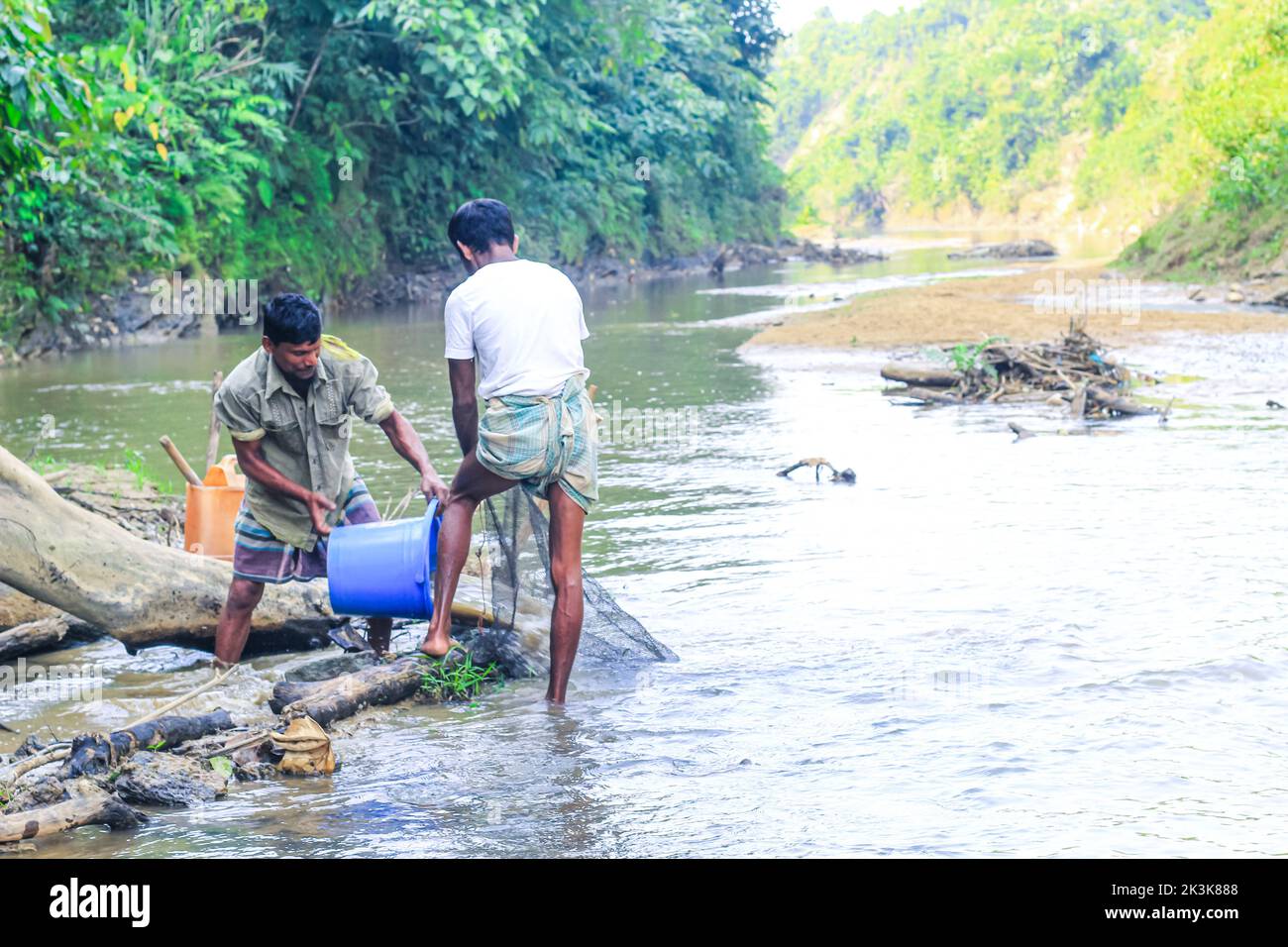 Tribal fishermen catch fish with fishing nets in the creek. Tribals