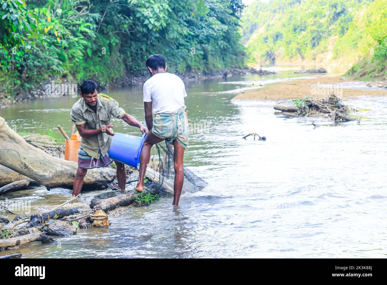 Tribal fishermen catch fish with fishing nets in the creek. Tribals