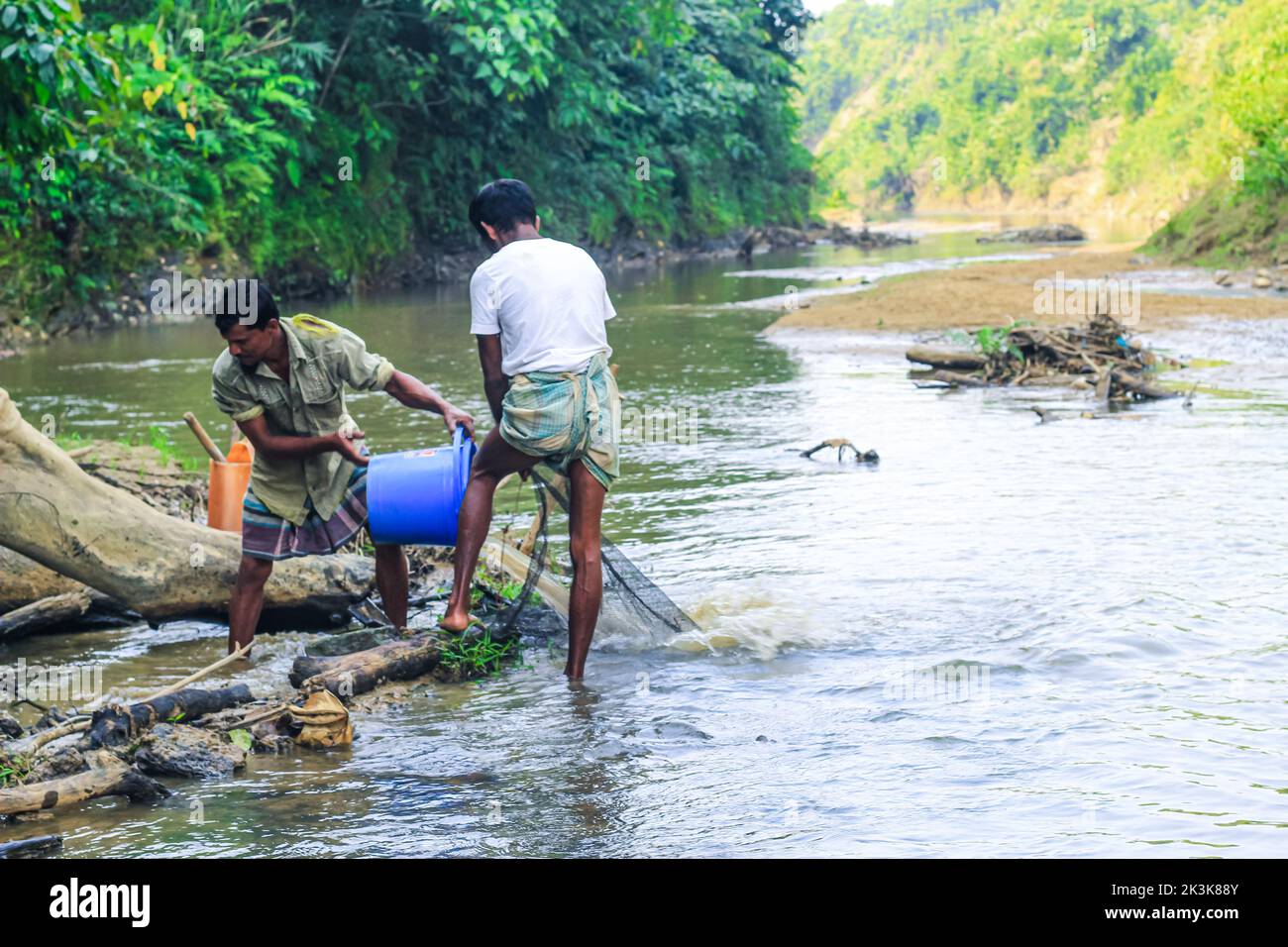 Tribal fishermen catch fish with fishing nets in the creek. Tribals