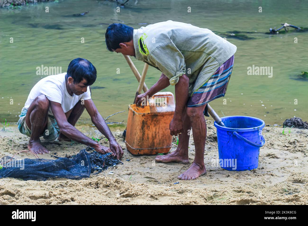 Tribal fishermen catch fish with fishing nets in the creek. Tribals