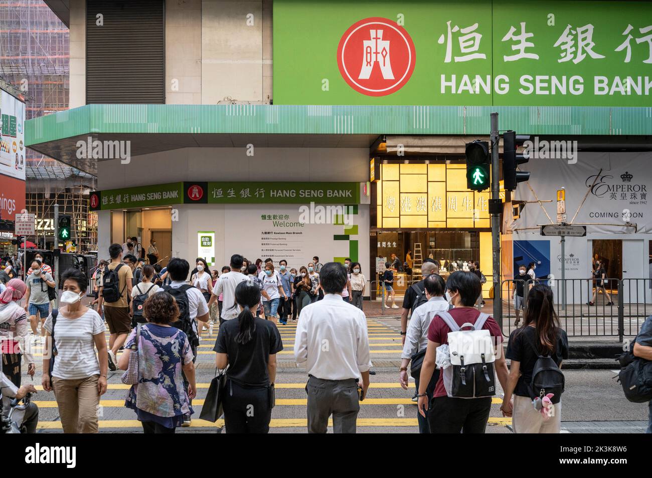 Pedestrians are seen crossing the street in front of the Hong Kong-based banking and financial services company, Hang Seng Bank, branch in Hong Kong. Stock Photo