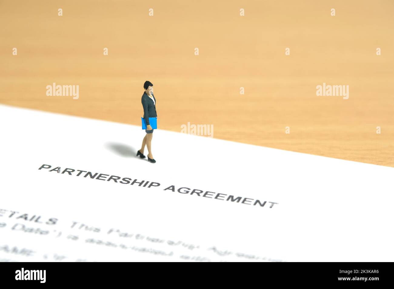 Miniature people toy figure photography. Business partner contract sign concept. A businesswoman walking above partnership agreement file document. Im Stock Photo