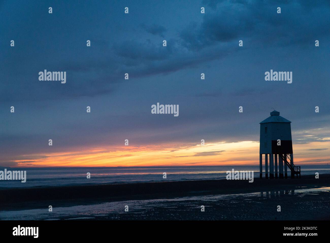 Sunset from the beach at Burnham-on-Sea, Somerset, in the south-west of England, where a low wooden lighthouse was built in 1832. The west-facing beac Stock Photo