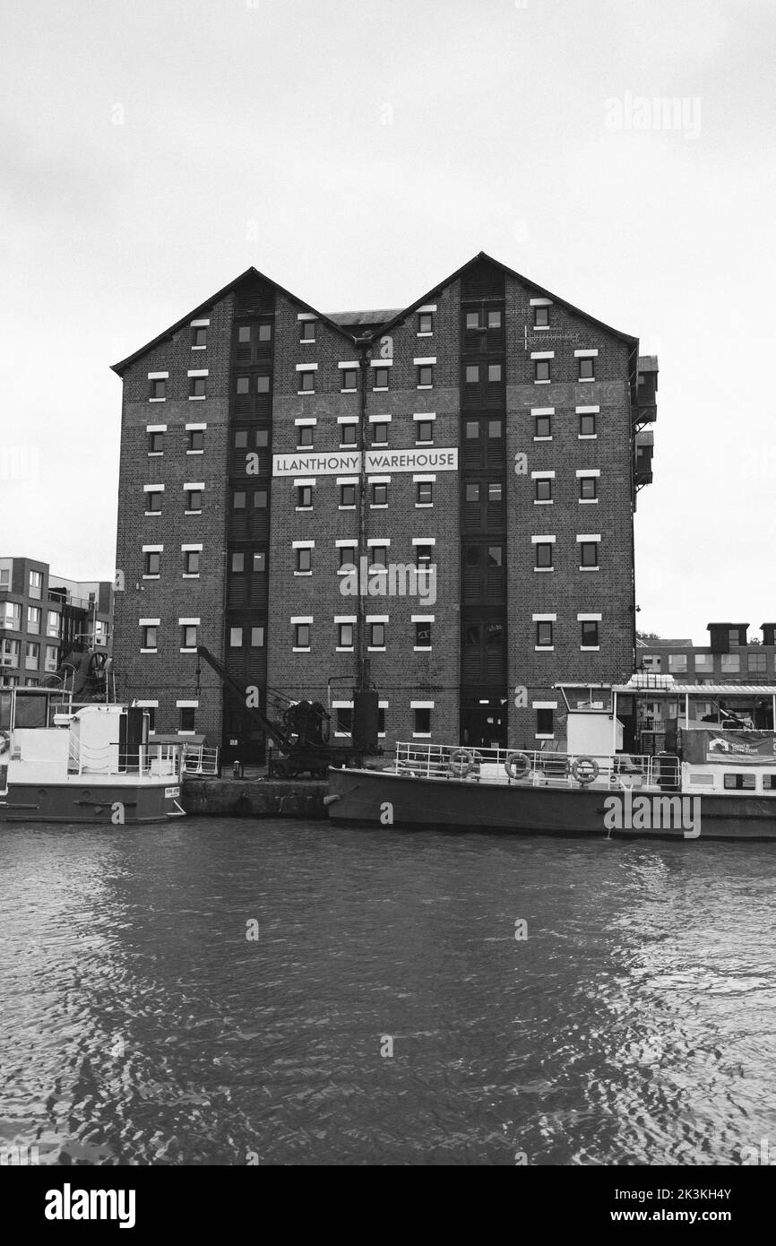 A vertical grayscale shot of dock buildings and canal boats Stock Photo ...