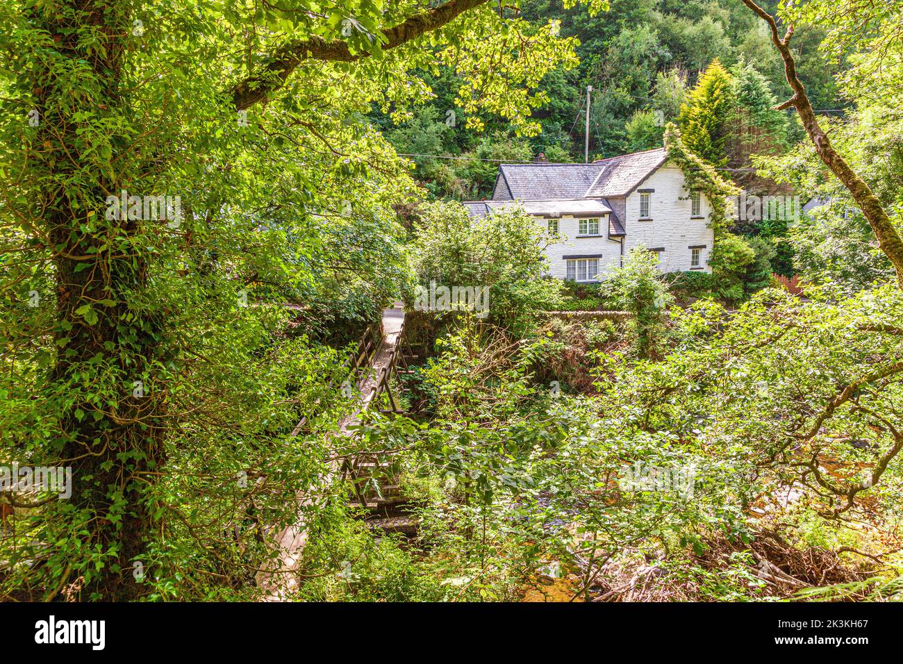 A glimpse of the village of Rockford from The Coleridge Way beside the East Lyn River on Exmoor National Park, Rockford, Devon UK Stock Photo