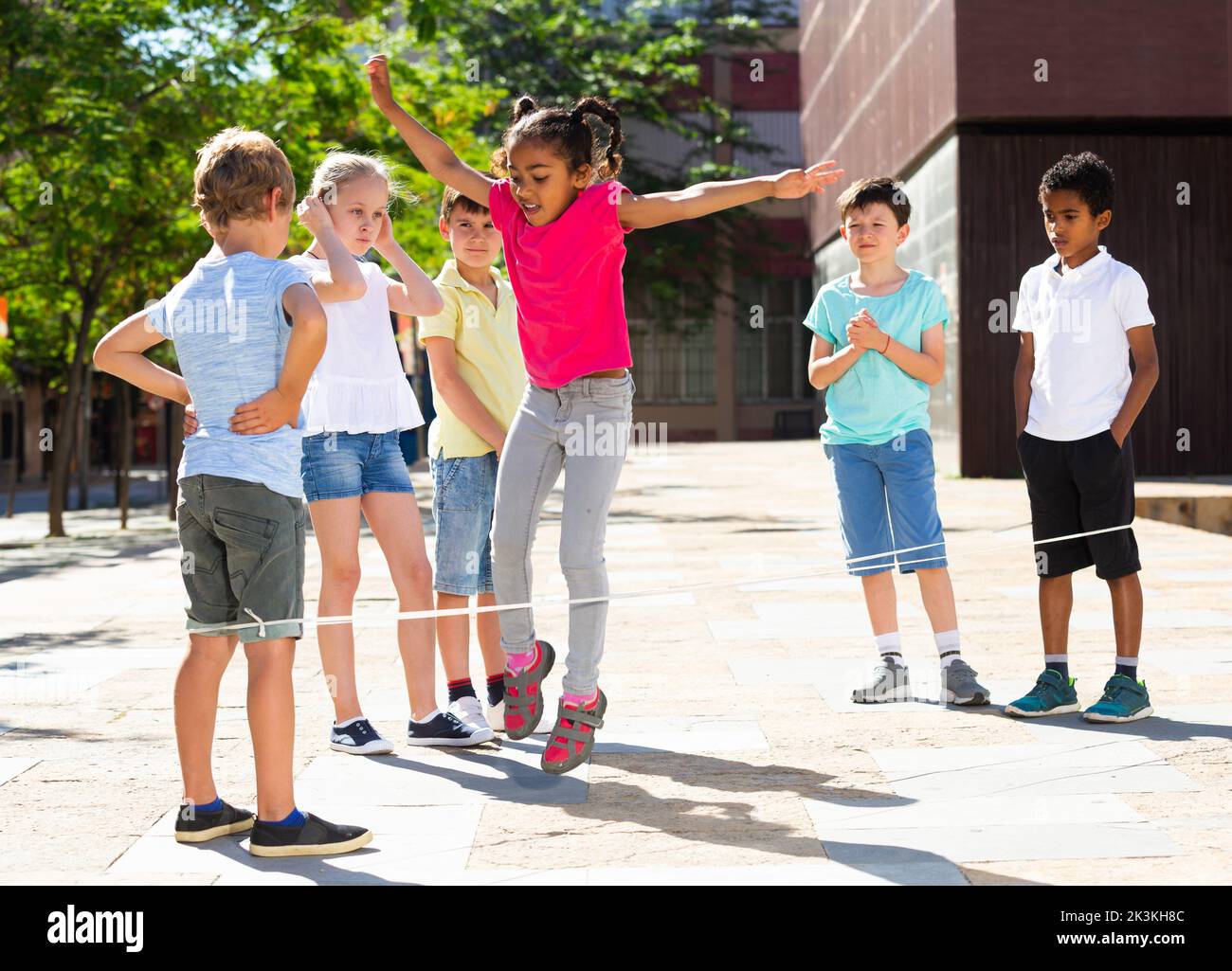 Happy children jumping game by rubber band and laughing Stock Photo Alamy