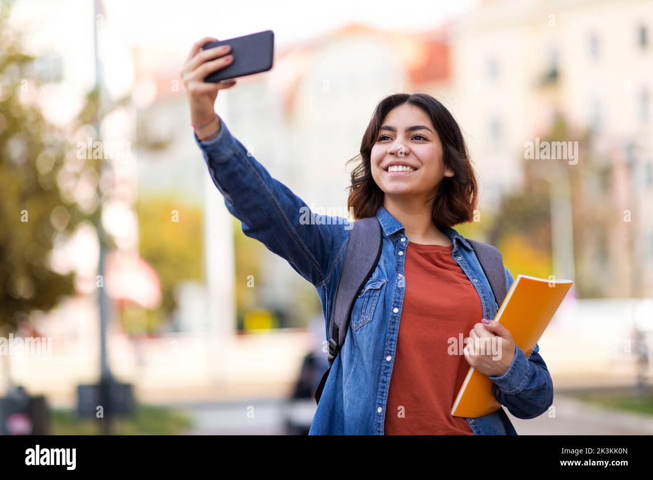 Cheerful Arab Female Student Taking Selfie With Smartphone Outdoors Stock Photo