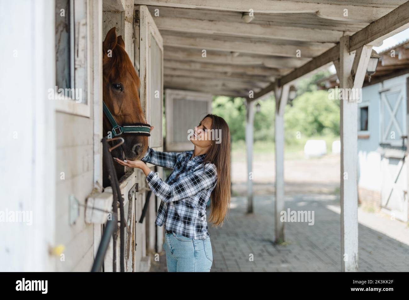 Young woman in a stable with her horse Stock Photo - Alamy