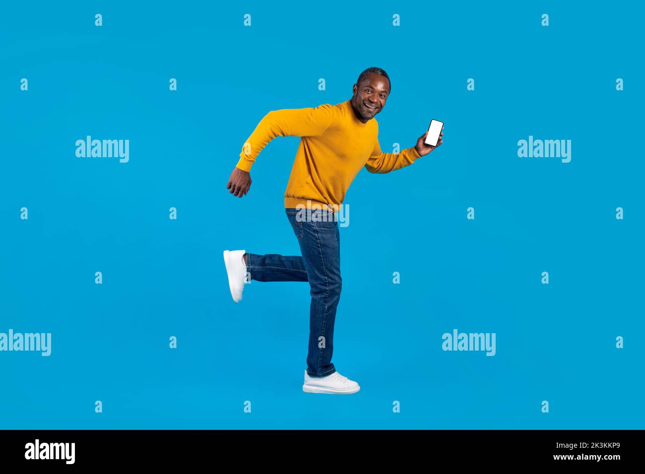 Funny black man running away with smartphone in his hand Stock Photo